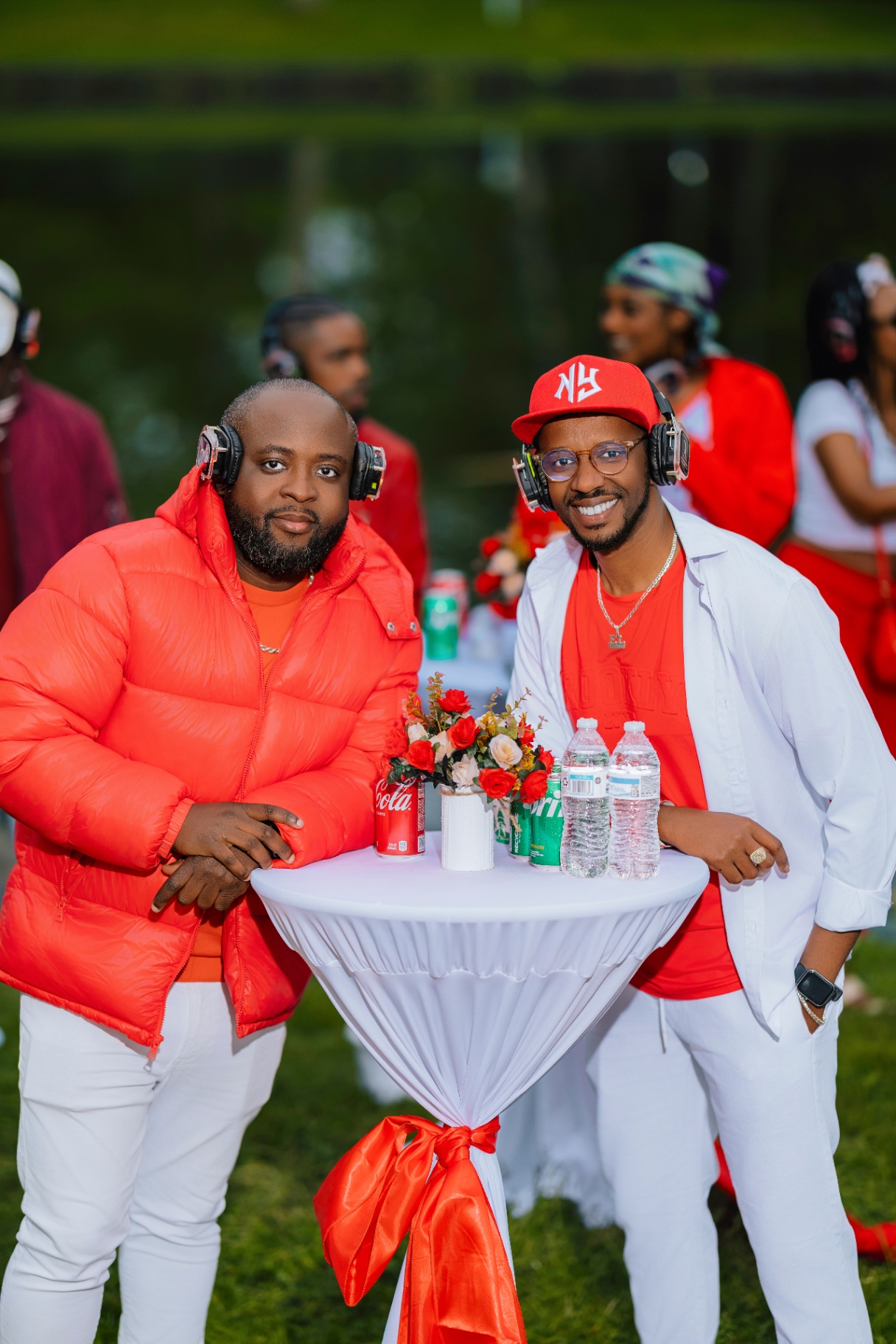 Two guests leaning on a cocktail table with red bow